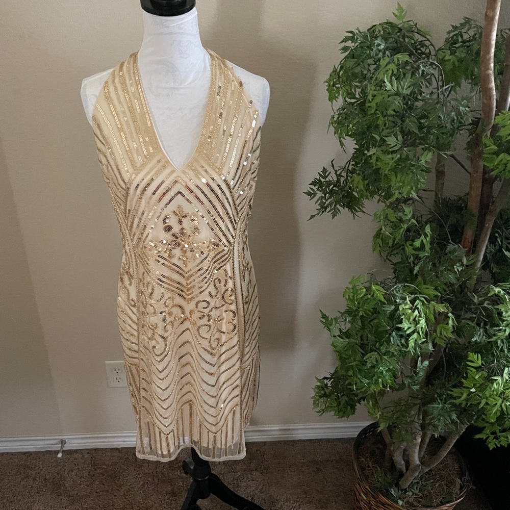 Cream halter dress with gold sequin accents.